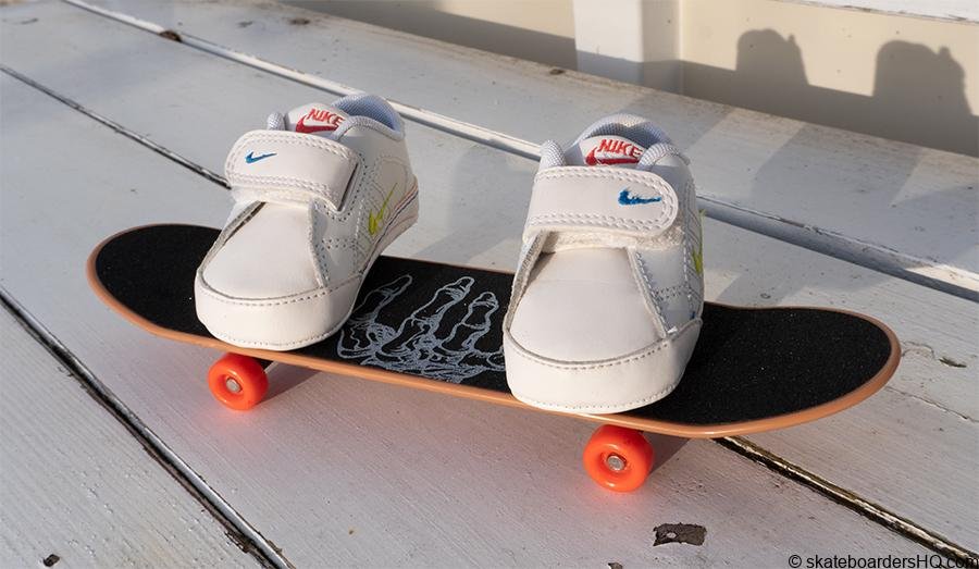 baby sneakers on a hand skateboard